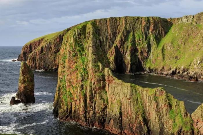 Impresión enmarcada : Vista dramática de la costa en Westerwick, acantilados rojos y arrecifes de granito con estacas. Isla Principal Occidental
