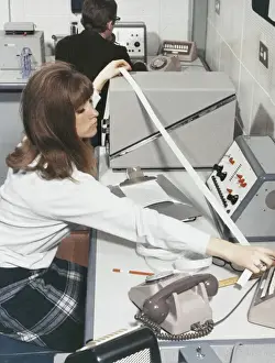 Technician At Work Imprime: A computer technician with data tape