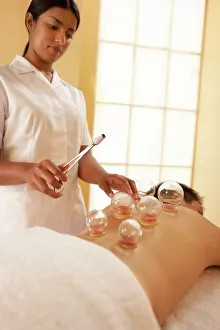 Impresiones de El modelo ha sido liberado. El masaje de tumbesca. El terapeuta calienta las tumbesca en la espalda del cliente Imágenes fechadas en abril de 2006: Cupping