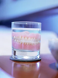 Impresiones de Dientes falsos en un vaso de agua. Las dentaduras se adaptan individualmente a una persona específica concreta. Reemplazan los dientes perdidos por lesiones o enfermedades Imágenes fechadas en 2003: Dientes falsos