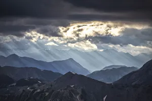Sunset In Italy Imprime: Sun rays filter between black clouds at sunset