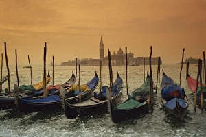 Gondolas In Venice Imprime: View past docked gondolas towards St. Marks Square, from across the Grand Canal