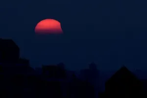 Solar Imprime: Una eclipsión parcial del sol, mientras se pone el sol, es vista desde Shanghái