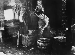 19th Century Occupations Imprime: BLACKSMITH AT WORK. A blacksmith and assistant at work. Undated photograph