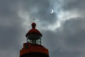 Brittany Coast Scenery Imprime: Solar eclipse in a cloudy sky above the lighthouse at Pointe Saint-Mathieu