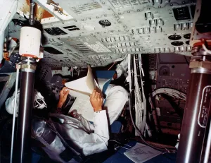 Manned Spaceflight History Imprime: An astronaut inside a NASA Command Module, 1970s. Artist: NASA