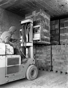 Michael Walters Photography UK Imprime: A yardsman stacking pallets of bricks