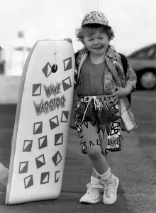 00031 Imprime: Moda - Vestimenta de playa: Whizkid en la tabla. Ella apenas es más grande que la tabla.