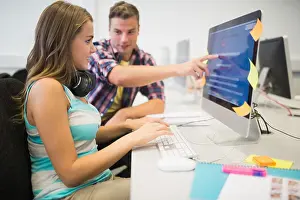 Clases sonrientes haciendo un trabajo en conjunto en la sala de computadoras.
