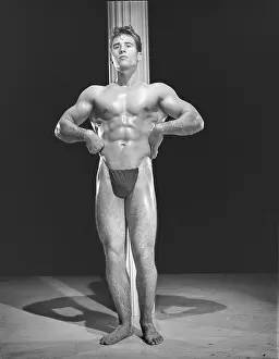 Black And White Muscular Men Imprime: Bodybuilder Poses In Front Of Pole c.1954