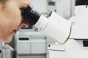 Scientific Experiment Imprime: Scientist looking through microscope