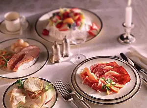 Una mesa para un banquete formal con charcutería, salmón a la parrilla y pavlova.