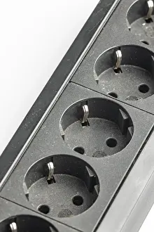 Electricity Infrastructure Imprime: Part of a black plastic socket strip with empty sockets
