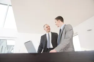Professional Discussion Imprime: Boss and trainee working together on a computer