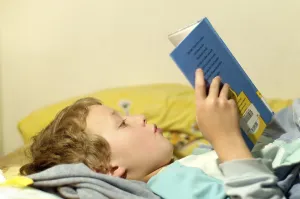 Boy Reading In Bed Imprime: Boy reading in bed