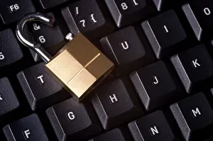 Computer Hacking Prevention Imprime: A broken padlock on top a computer keyboard to represent the concept of computer security breach