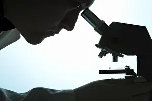 Indoor Studio Photography Imprime: Chemist looking through a microscope