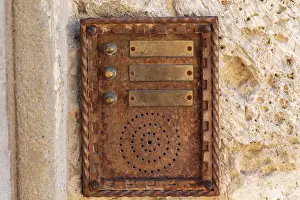 Traditional Building Design Imprime: Close up of an old rusty intercom embedded in weathered stone wall