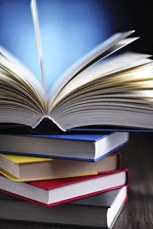 University College Study Space Imprime: A composition with an open book lying on a stack of other books