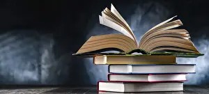 Educational Institution Imprime: A composition with an open book lying on a stack of other books