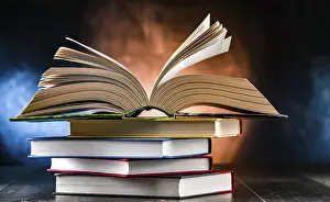 Book Stack Imprime: A composition with an open book lying on a stack of other books