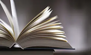 Open Book Imprime: A composition with an open book lying on a stack of other books
