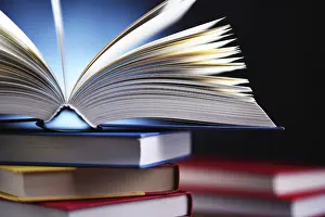 Educational Institution Imprime: A composition with an open book lying on a stack of other books