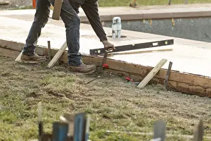 Construction Industry Jobs Imprime: Construction worker checking level on wet deck cement