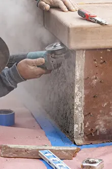 Construction Industry Staff Imprime: Construction worker using grinder at construction site