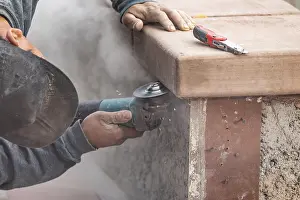 Male Construction Worker Imprime: Construction worker using grinder at construction site