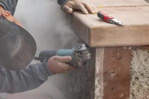 Male Construction Worker Imprime: Construction worker using grinder at construction site