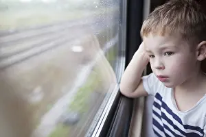 Boy Looking Out Window Imprime: Curious boy looking out the window of a speeding train