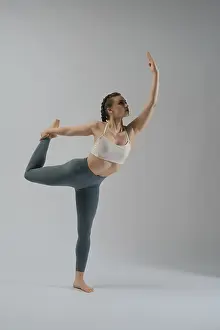 Minimalist Studio Shot Imprime: A dancer showcases her flexibility and strength while executing an elegant pose in a studio