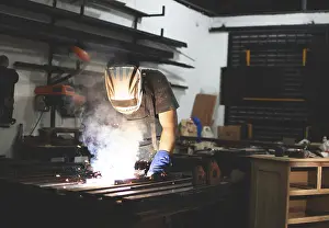 Factory Interior Photography Imprime: Deaf man using a welding torch in the workshop