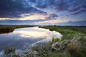 Río Imprime: Puesta del sol tranquila y dramática sobre un río.