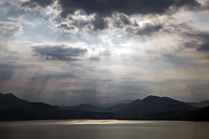 Dramatic Cloud Formation Imprime: Dramatic cloud formation, sunbeams behind dark clouds