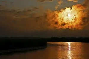 Atmospheric Evening Light Sky Imprime: Dramatic cloud formation at sunset reflected in a calm river