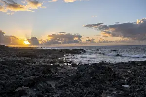 Volcanic Rock Coast Imprime: Dramatic cloudy sky with sunbeams at sunset