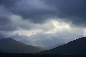 Dramatic Mountain Landscape Imprime: Dramatic mountain landscape under cloudy sky with rays of light