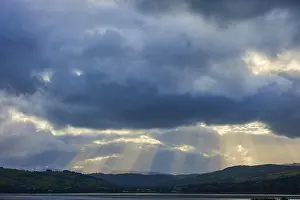 Mountainous Scenery UK Imprime: Dramatic sky with rays of light breaking through the clouds over a mountainous landscape
