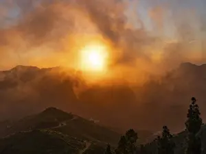 Cloudy Evening Sky Photography Imprime: Dramatic sunset lighting up the clouds and mist over the mountains