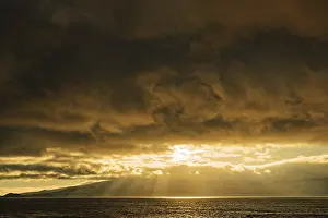 Deserted Beach Evening Atmosphere Imprime: Dramatic sunset with sun rays breaking through the clouds over the sea