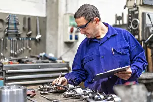 Factory Worker Imprime: Factory worker operator of the numerical control sector measuring the drill bits