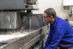 Factory Worker Imprime: Factory worker operator in the numerical control sector preparing a machine