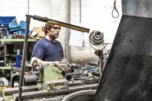 Factory Worker Imprime: Factory worker operator in the numerical control sector working on a machine