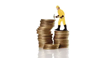 Symbolic Construction Image Imprime: Figure of a construction worker with hard hat and pickaxe on a stack of coins