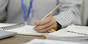 Office Communication Skills Imprime: A focused professional writes notes in a notebook