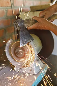 Handicraft Tools Imprime: Grinding table ax with a grinding machine at close range