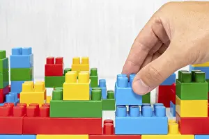 Deserted Construction Site Imprime: Hand building up a wall by stacking up block