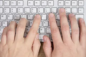 Empty Workspace Imprime: Hands typing on a computer keyboard